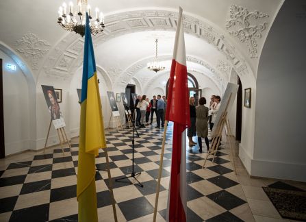 Fotografia. Wernisaż wystawy piękno jedności. flaga polska i ukraińska, w tle hol główny willi decjusza.